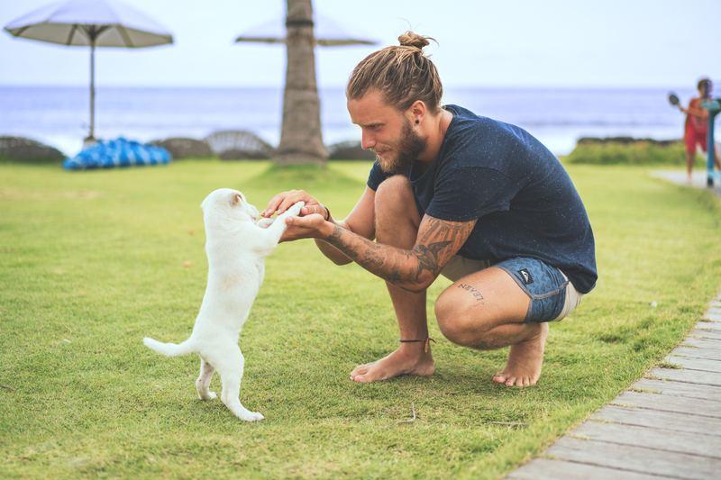 man playing with his puppy